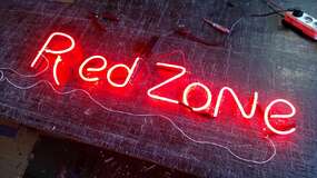 неоновая вывеска red zone в цеху на тренировке